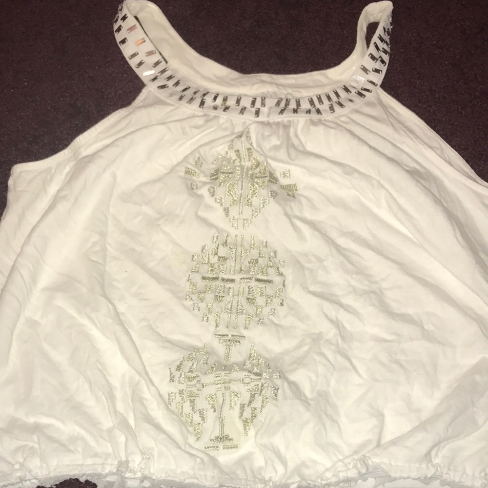 A white tank top with gold on it
